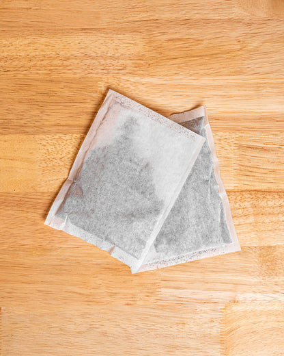 A filter pack of iced tea used for brewing fresh iced tea sitting on a wood table