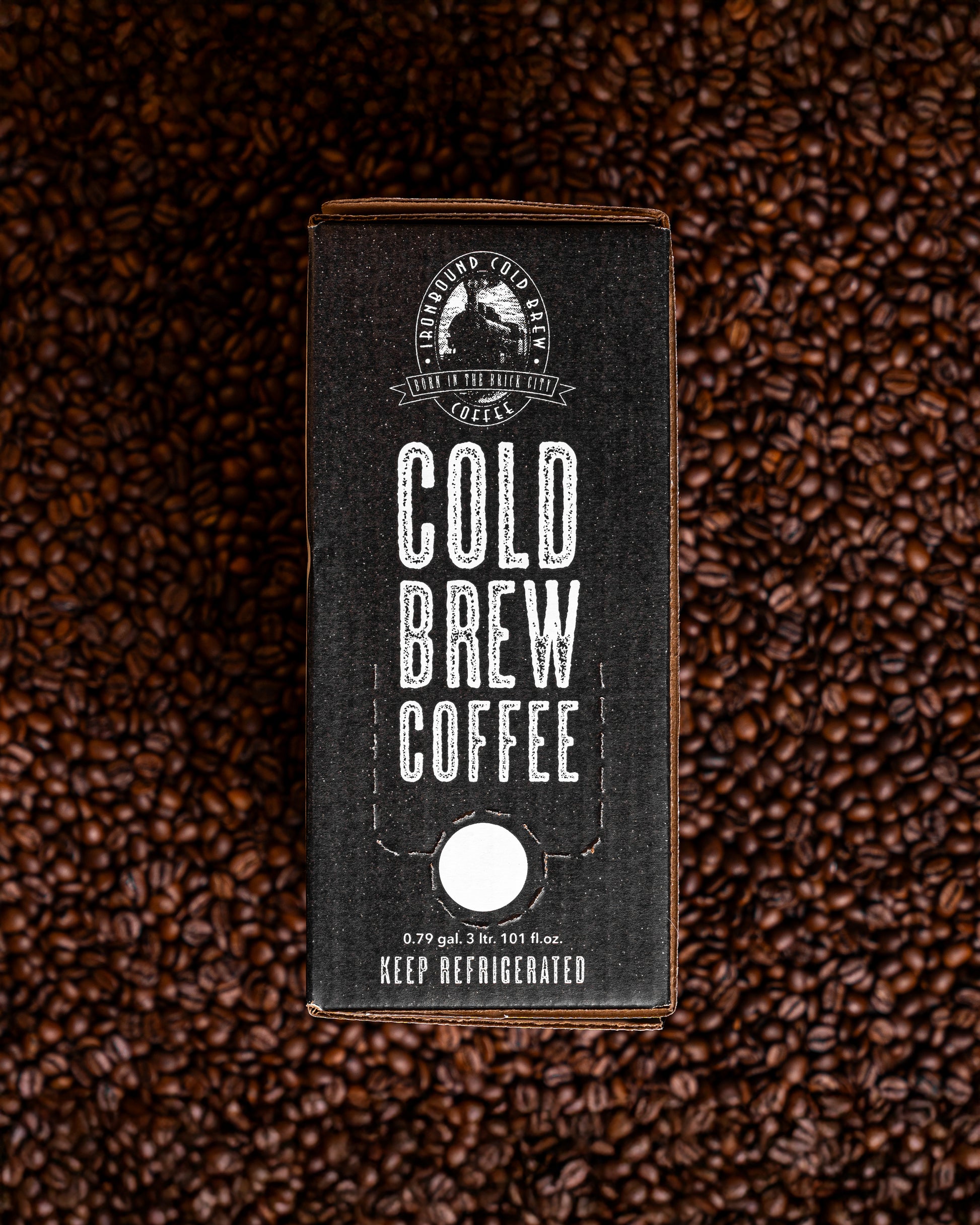 Our 3L Ironbound Cold Brew Coffee bag in the box sitting on a bed of coffee beans.