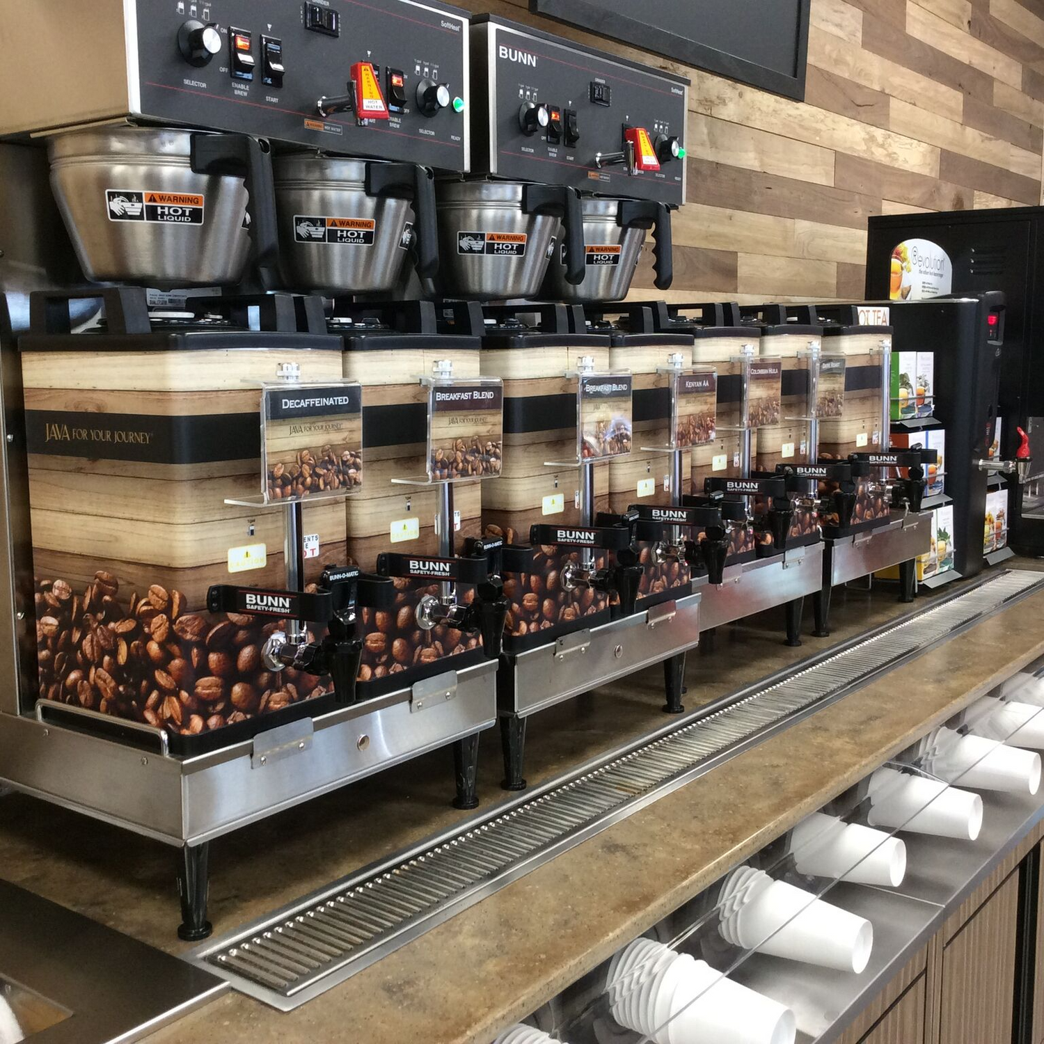 A view at a retail coffee counter with several Bunn soft heat brewers. 