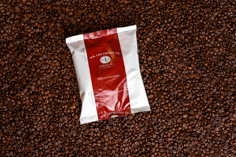 a WB Law Coffee 7oz frac pack sitting on a bed of coffee beans