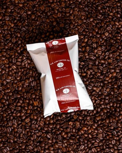 a frac pack of ground organic colombian coffee on a bed of coffee beans
