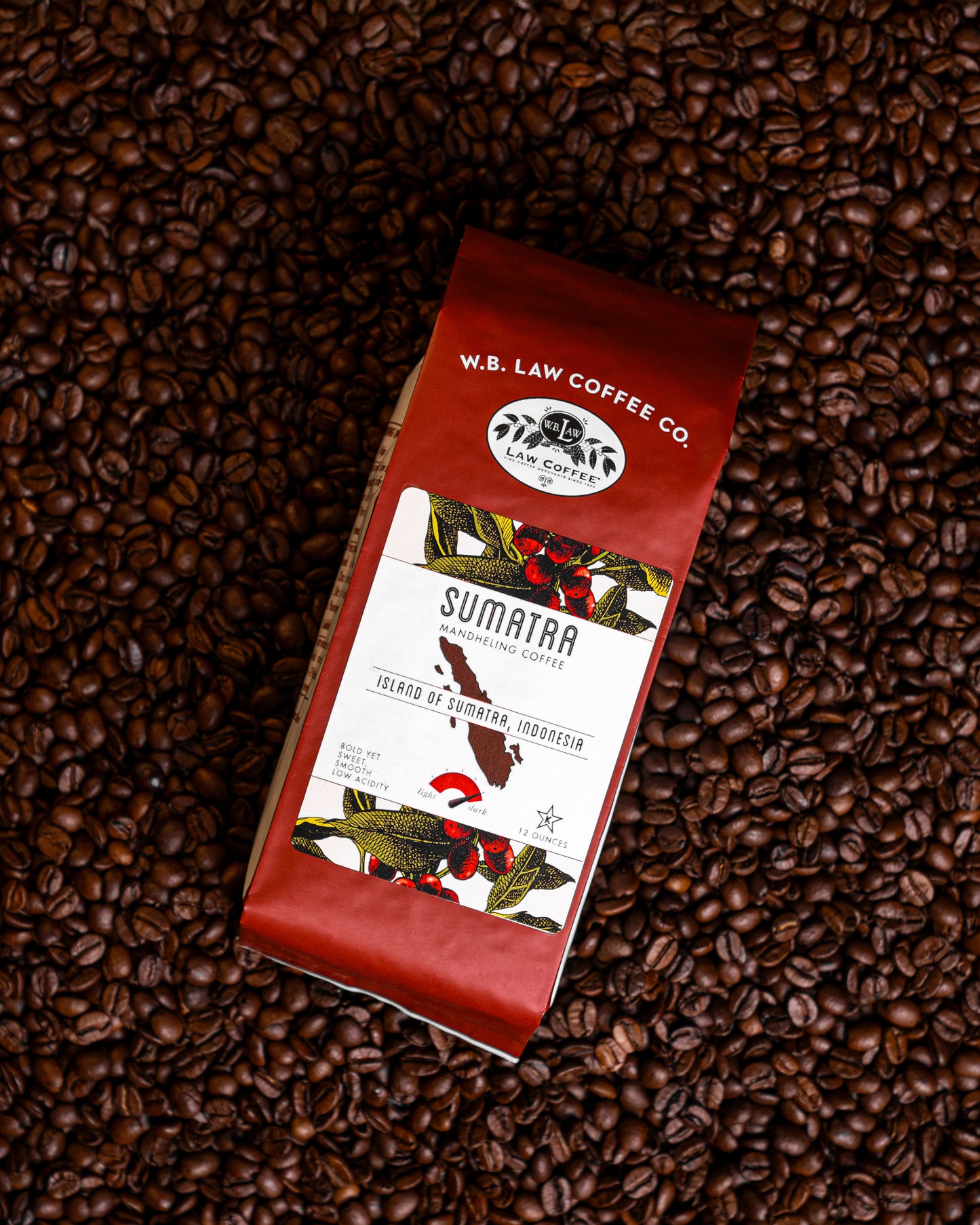a 12oz bag of WB Law Coffee Sumatran Mandheling coffee on top of a bed of coffee beans
