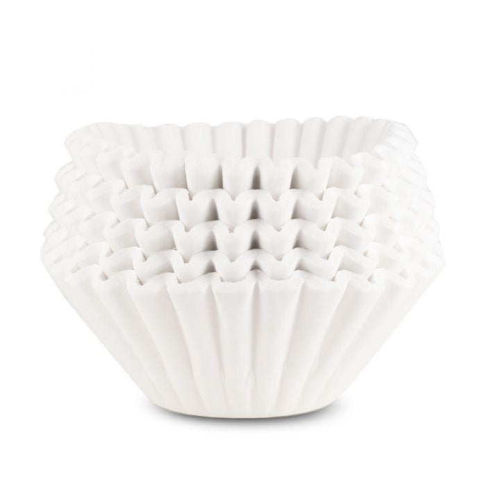 A stack of white 13x5  coffee filters used for brewing in commercial coffee brewers. 