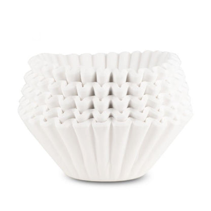 A stack of white 13x5  coffee filters used for brewing in commercial coffee brewers. 