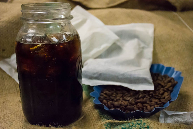 A mason jar of cold brew coffee next to our cold brew coffee filter packs.