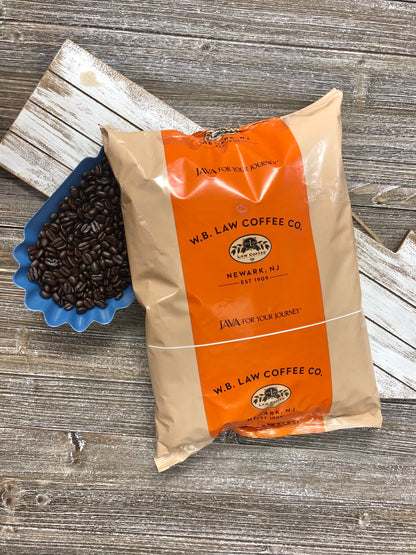 a bag of WB Law Coffee premium decaf coffee beans sitting on a wood table